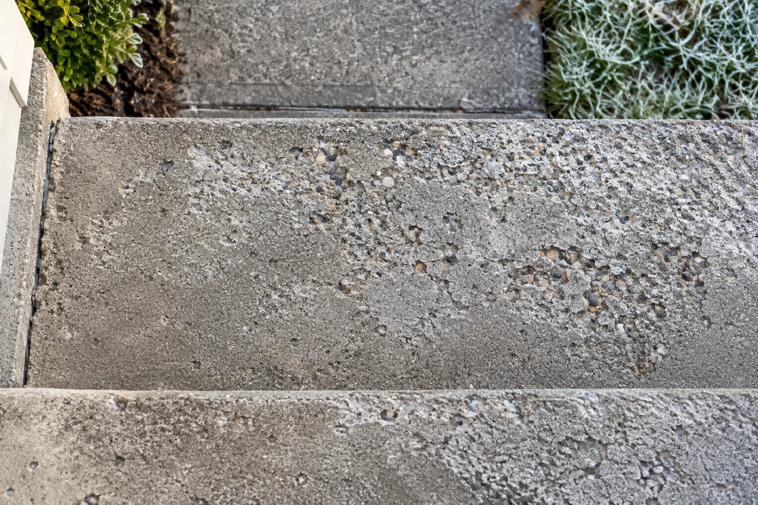 Freeze-thaw scaling and pop-outs on a concrete step