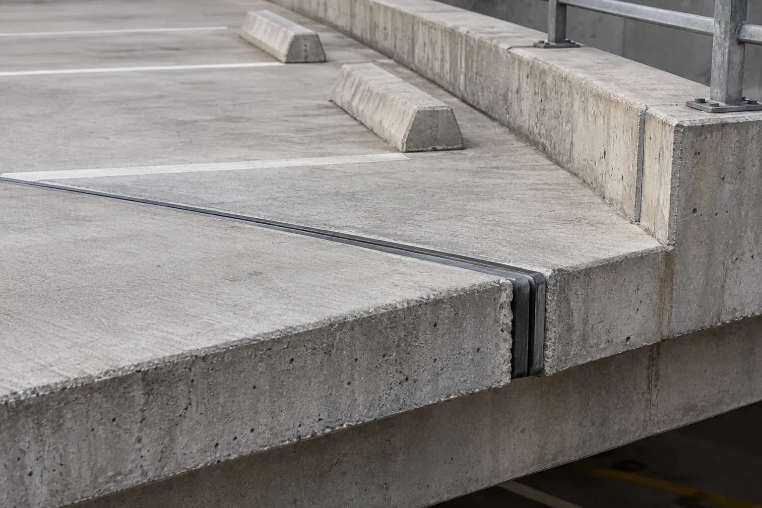 Edge of a parking garage concrete deck showing slab thickness at a ramp