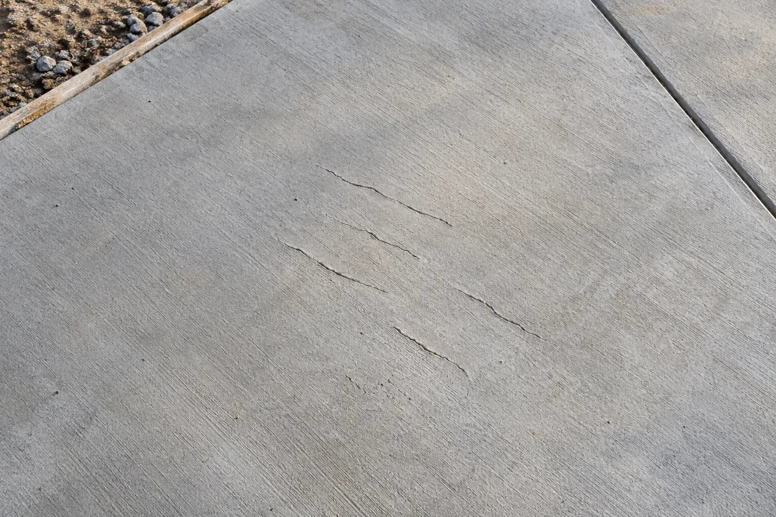 Short parallel plastic shrinkage cracks in a recently poured slab