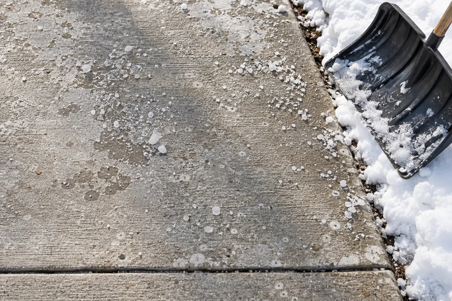 Winter salt and scaling damage on a concrete walkway